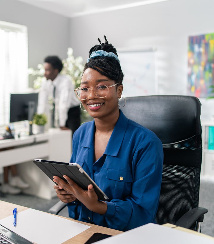 woman at desk holding a tablet