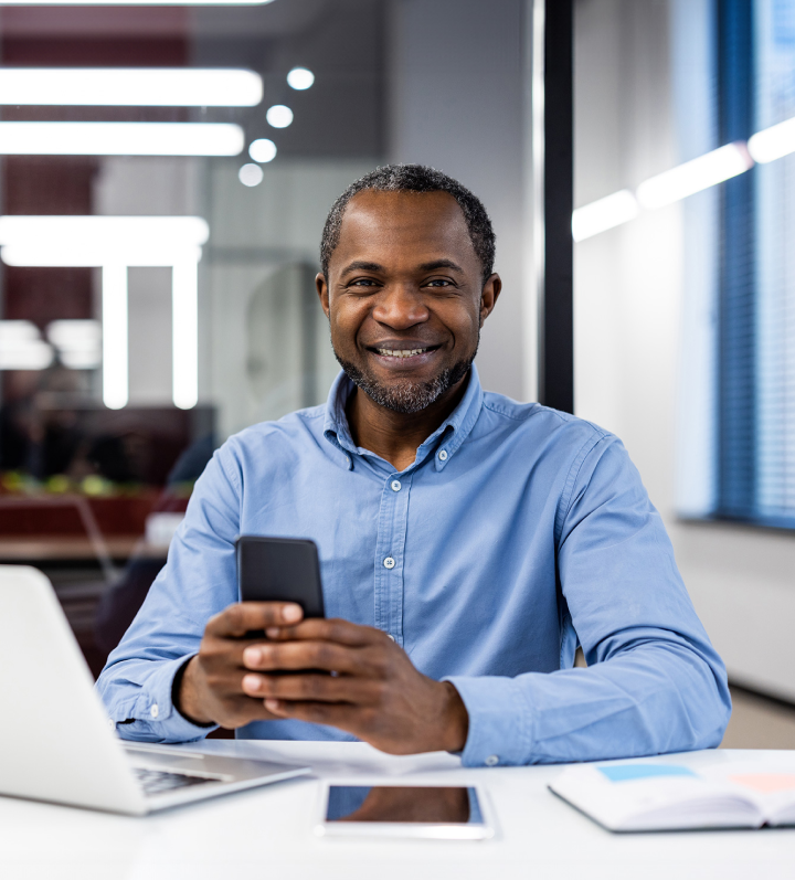 man smiling and holding phone