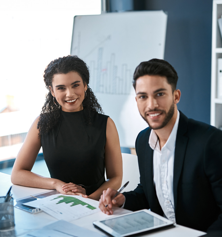 two people smiling at desk