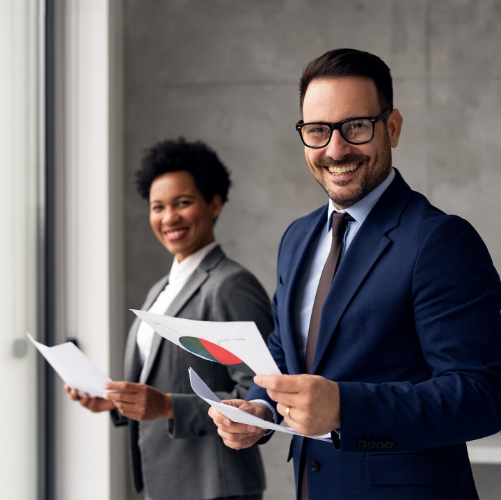 two people smiling holding documents