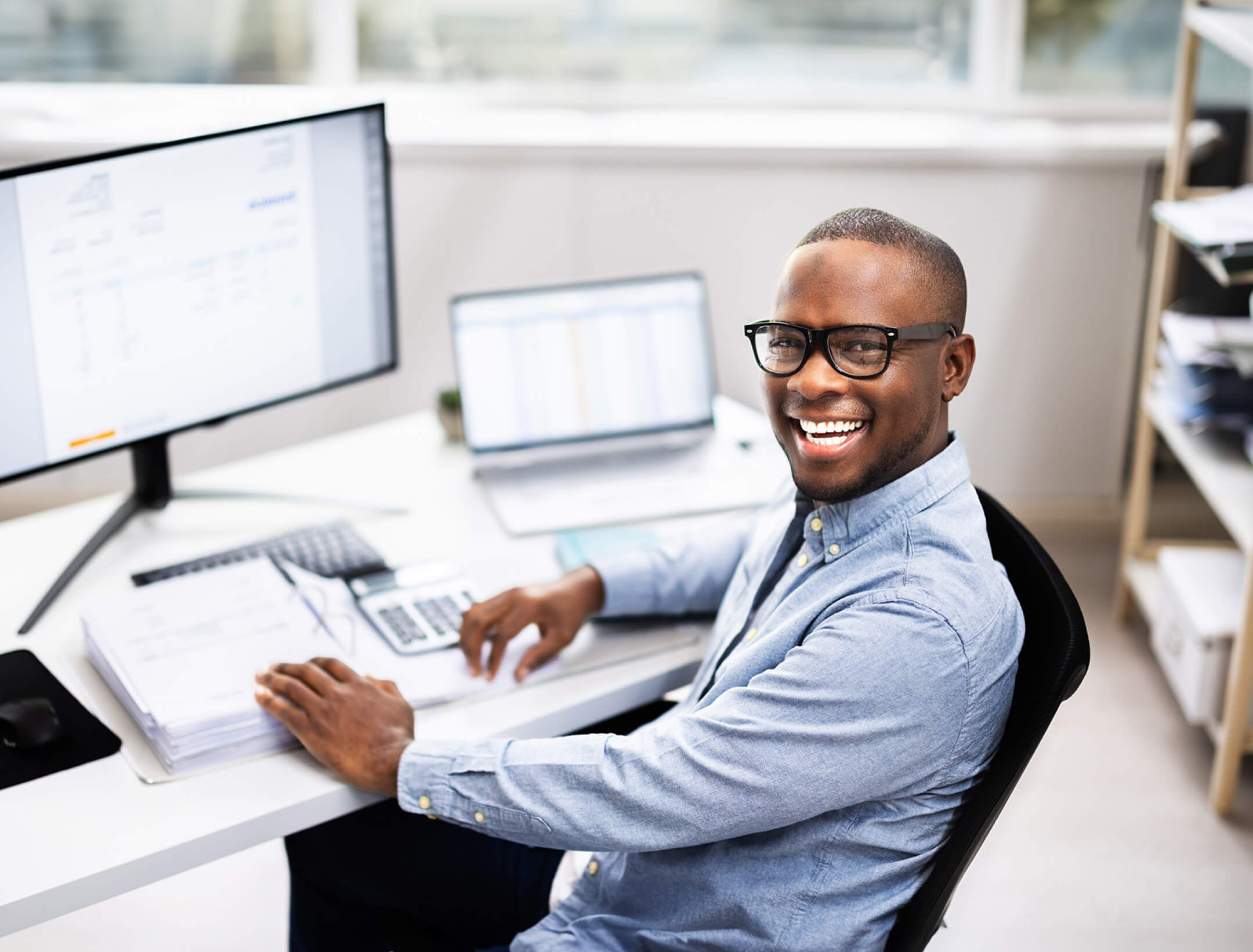 man smiling at his desk