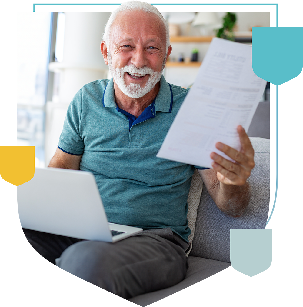 man smiling holding a document and laptop